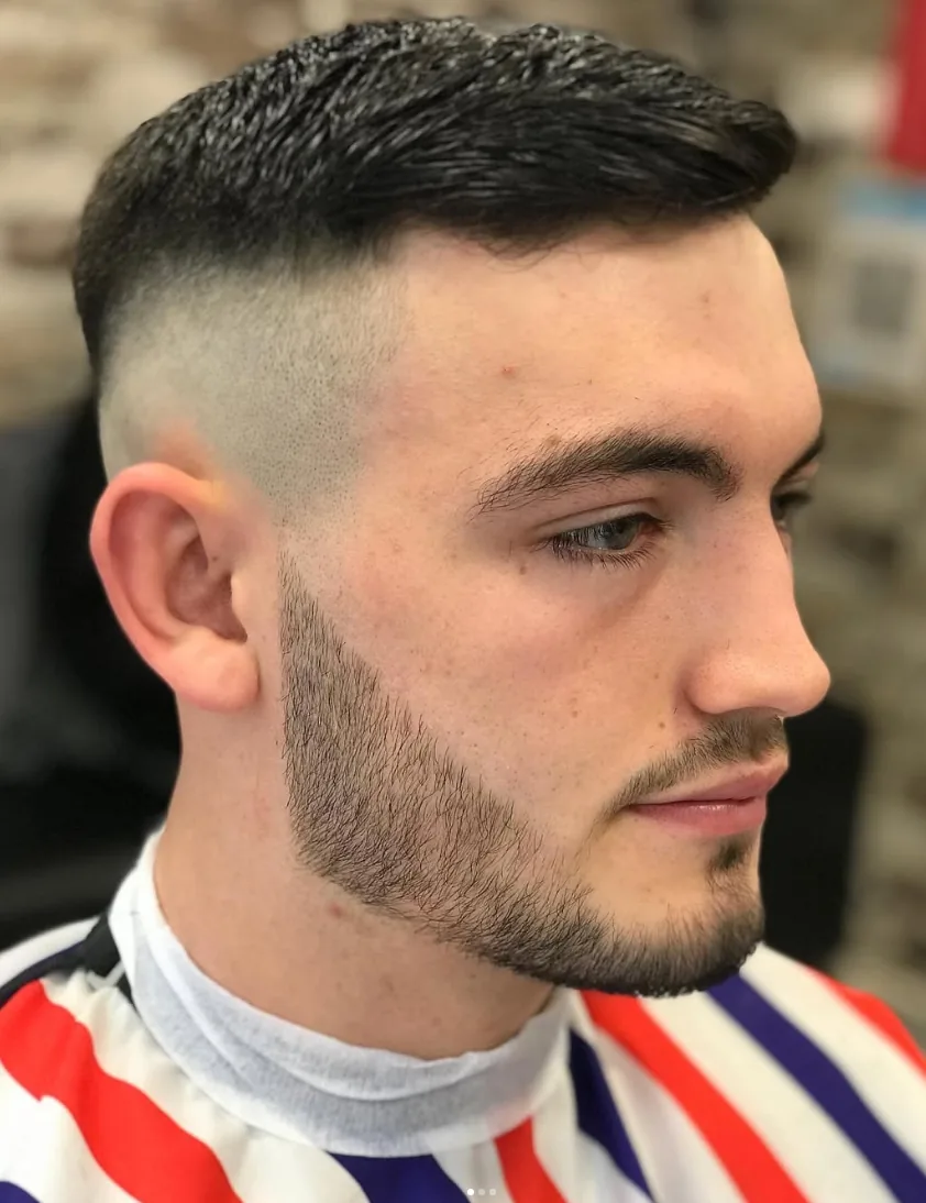 Close-up of a sharp skin fade with a shaped beard line
