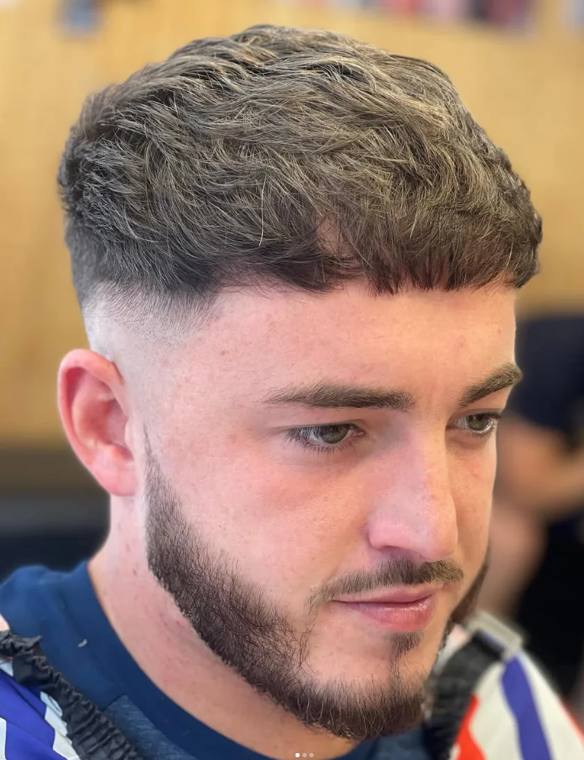 Close-up of a textured crop with a clean fade and shaped beard